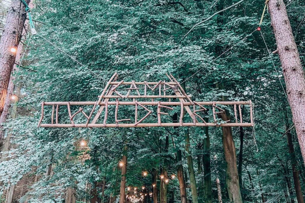 camp wildfire sign hanging from two trees either side